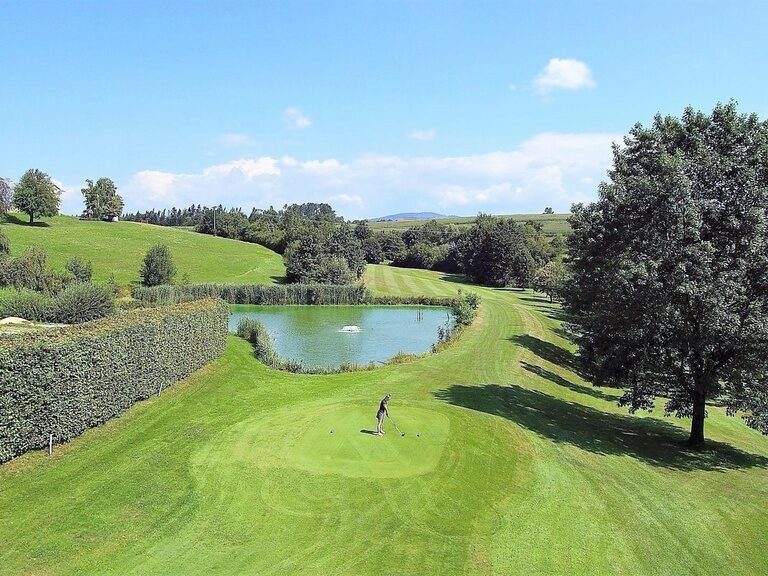 Luftaufnhame eines Golfers, der auf der hauseigenen Golfanlage des Hotel Anetseder zum Abschlag bereit steht.