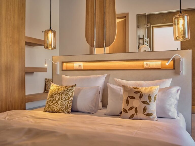 Das stilvoll eingerichtete Schlafzimmer der Spa Loft im Golf- und Landhotel Anetseder besticht durch ein gemütliches Bett und harmonisches Design.