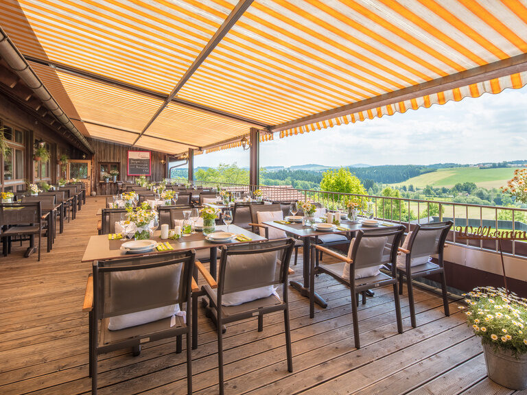 Gemütliche Möbel und eine wunderbare Aussicht machen die Sonnenterrasse des Hotel Anetseder zu einem perfekten Ort zum Entspannen.