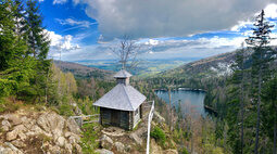 Ein malerischer Blick auf die Rachelkapelle im Nationalpark Bayerischer Wald mit See im Hintergrund