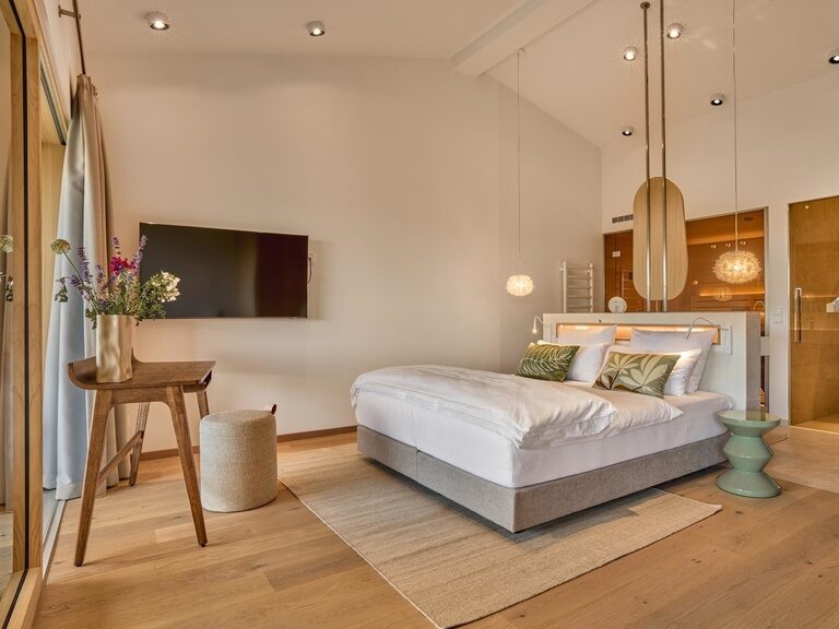 Das elegante Schlafzimmer der Spa Loft im Golf- und Landhotel Anetseder überzeugt mit einem gemütlichen Bett